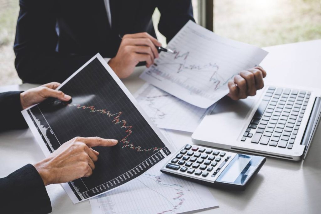 Business team colleagues working with computer, laptop, discussing and analysis graph stock market trading with stock chart data, financial and investment concept.