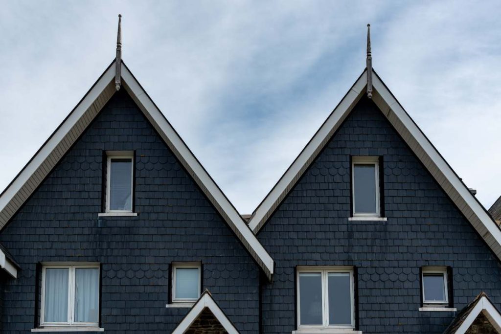 Wooden house roof attics against cloudy sky. Home residential building. Traditional british houses.