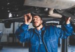 Auto mechanic inspects car suspension. Diagnostics of the condition of the car
