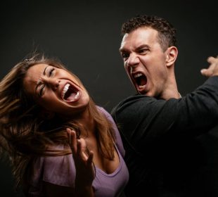 Angry aggressive husband trying to hit his wife.